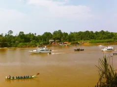 Baram Regatta sırasında Baram Nehri'nde yarışan geleneksel uzun kano ve arkada modern yatlar.