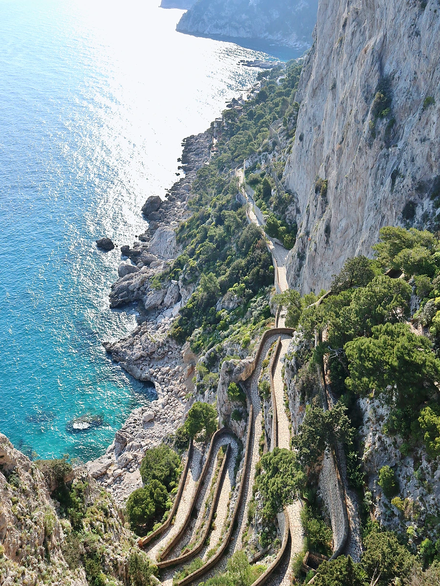 Capri'de deniz kıyısındaki dik uçurumlara inşa edilmiş tarihi Via Krupp yolu ve Akdeniz sahili.