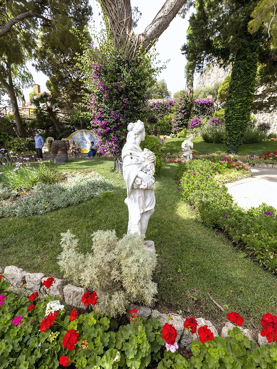 Capri Augustus Bahçeleri içerisinde çiçekler ve antik heykellerle çevrili yürüyüş parkuru.