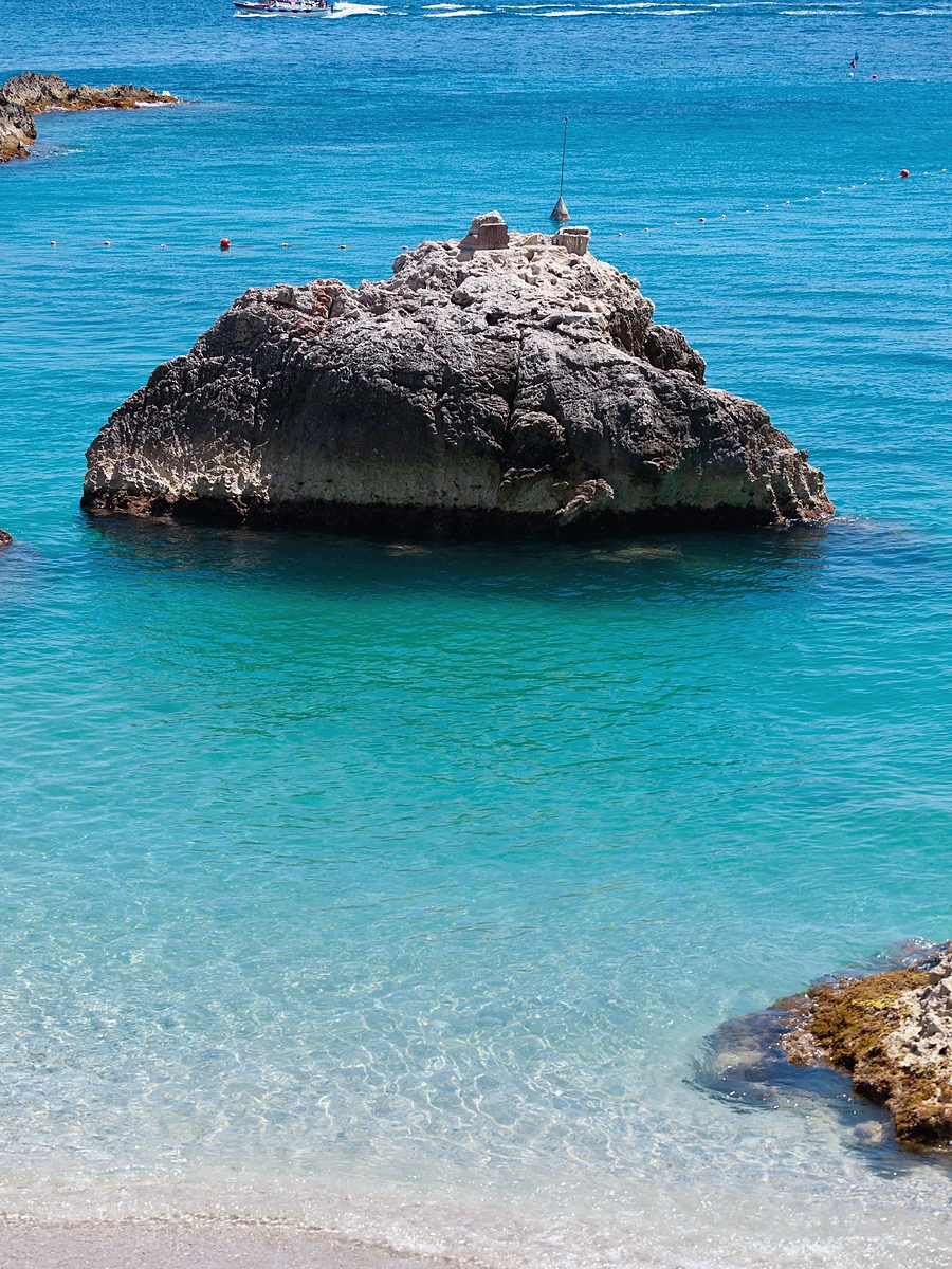 Capri Adası Marina Piccola plajında turkuaz deniz ve kıyıdaki karakteristik kayalıklar.