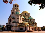 Sofya'daki altın kubbeli Aziz Aleksandr Nevski Katedrali'nin ağaç dalları arasından geniş açılı görünümü.