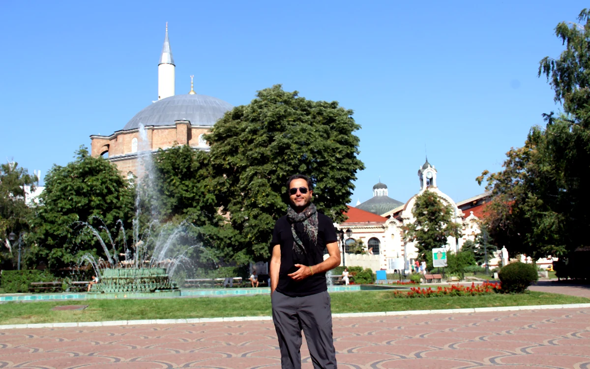 Sofya'da arka planda Banyabaşı Camii ve fıskiyeli havuzun bulunduğu meydanda poz veren Kemal Kaya