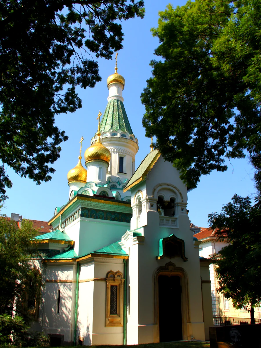 Sofya'daki Aziz Nikola Rus Kilisesi'nin ağaçlar arasından görünen altın kubbeleri ve yeşil çatısı.