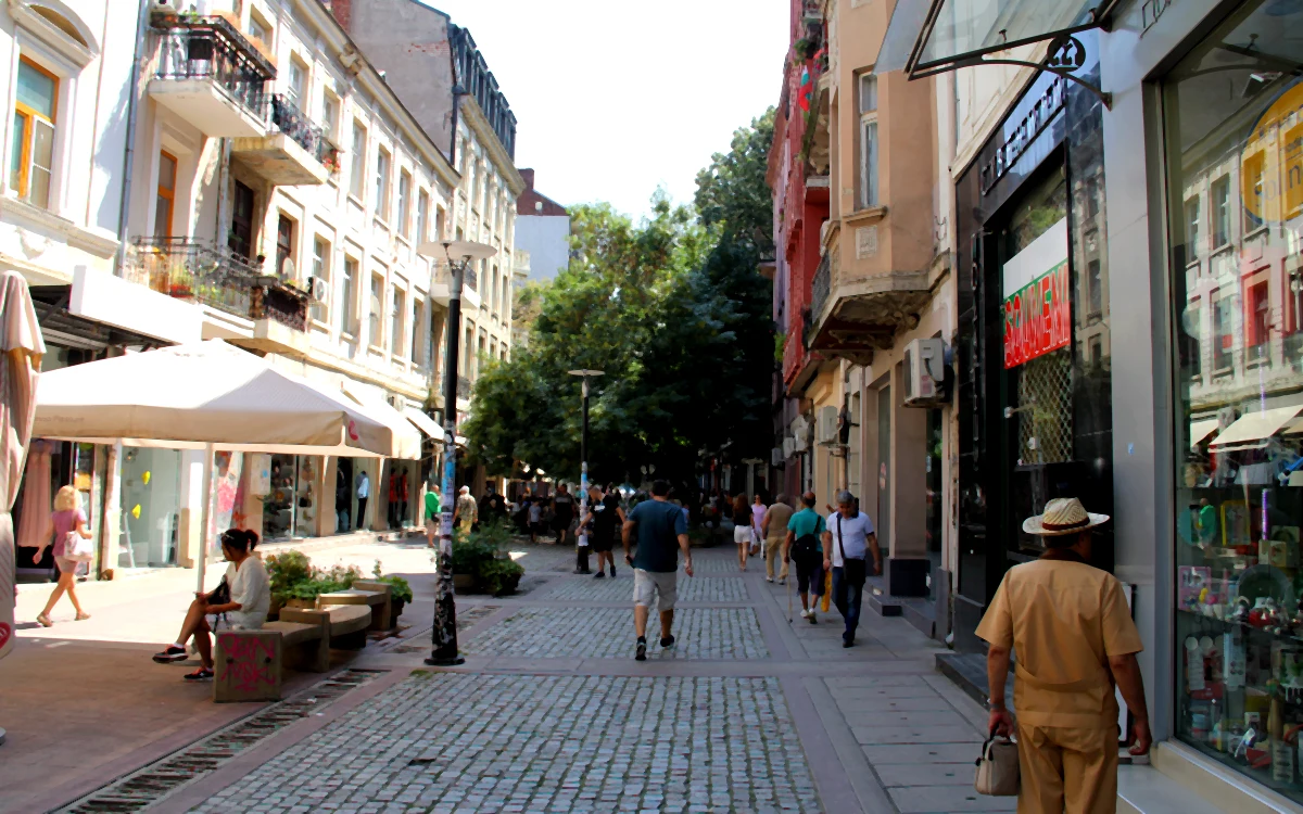 Sofya'daki tarihi Pirotska Caddesi'nde alışveriş yapan insanlar, yol kenarındaki dükkanlar ve kafeler.
