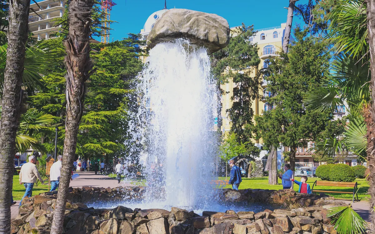 Batum 6 Mayıs Parkı içindeki taş detaylı fıskiye ve palmiye ağaçları