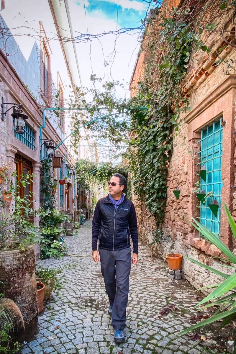 Ayvalık sokaklarında yürüyen gezgin, taş evler ve dar sokaklar