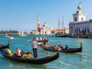Venedik kanallarında gondol turu yapan insanlar ve tarihi binalar