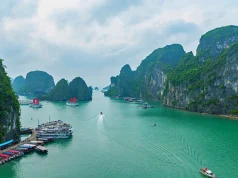 Halong Bay Vietnam’da sisli panoramik manzara, kireçtaşı kayalıklar ve deniz