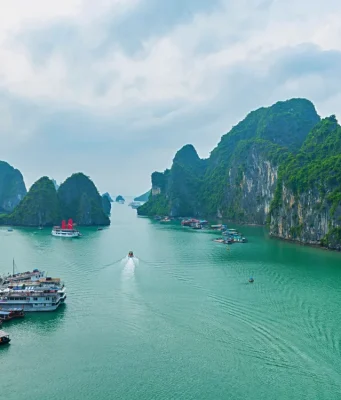 Halong Bay Vietnam’da sisli panoramik manzara, kireçtaşı kayalıklar ve deniz